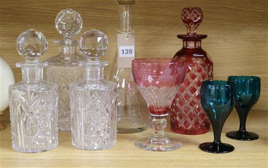 A ruby overlaid glass decanter, four other decanters and three glasses